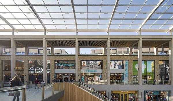 covered exterior mall environment with glass overhead covering and several levels of retail outlets